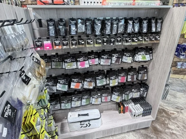 Rows of packaged fishing lures on pegboard