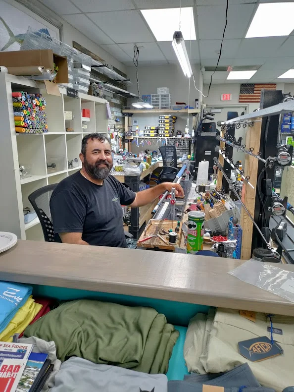 A Reel Quality SRQ team member behind the tackle shop counter