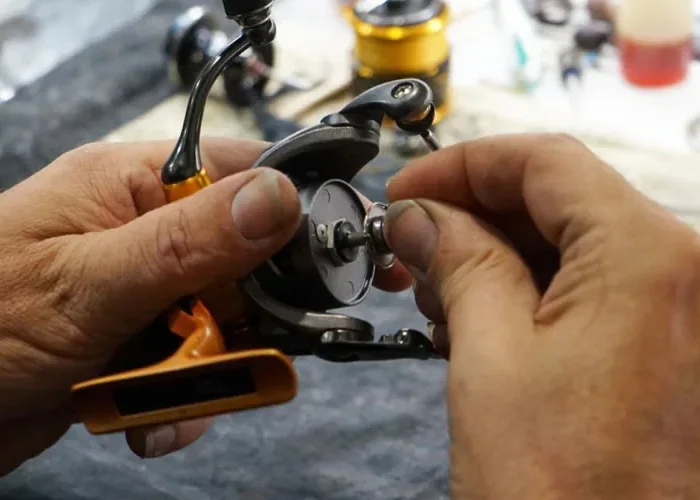 A technician working on the internal mechanism of a reel